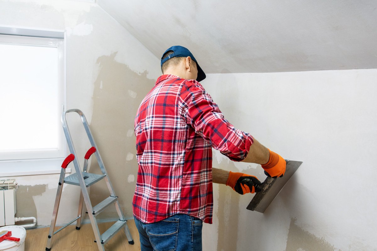 A man replacing drywall in an El Paso home.