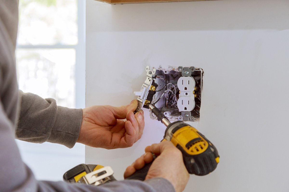 An electrician making an electrical repair to a power source in El Paso.