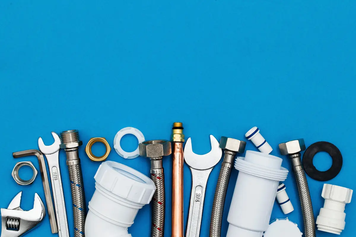 Various pieces of plumbing hardware against a blue background in El Paso.